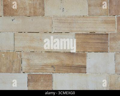 Sandstone facade with rectangular stones, grain, rough surface and horizontal pattern. Close-up. Copyspace. Stock Photo