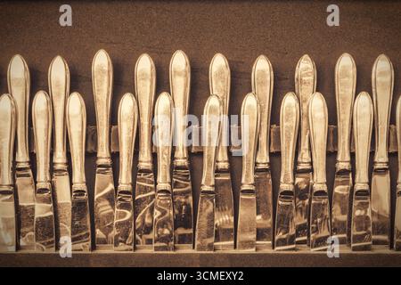 Retro styled image of a large collection of antique silver table knives Stock Photo