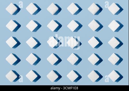 White sugar cubes arranged in rows on salmon orange background Stock Photo