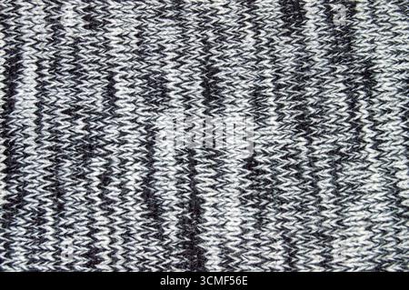 Close-up texture of a grey and white knitted wool fabric background. Seamless macro view of marled knit pattern material for sweater, clothing, and te Stock Photo