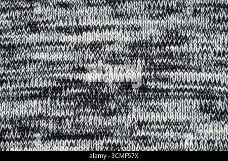 Close-up texture of a grey and white knitted wool fabric background. Seamless macro view of marled knit pattern material for sweater, clothing, and te Stock Photo