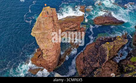 Old Man of Stoer Sutherland Scotland 200 ft sandstone sea stack five skilful climbers above the rocks and crashing waves Stock Photo