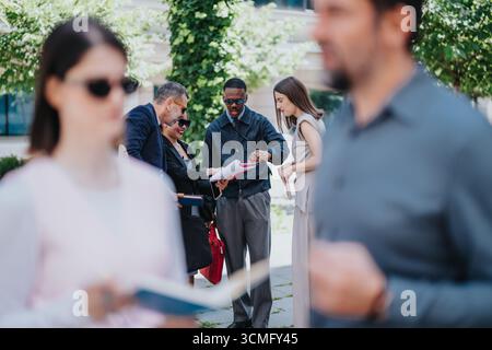 Diverse business team collaborating outdoors with blurred foreground details Stock Photo