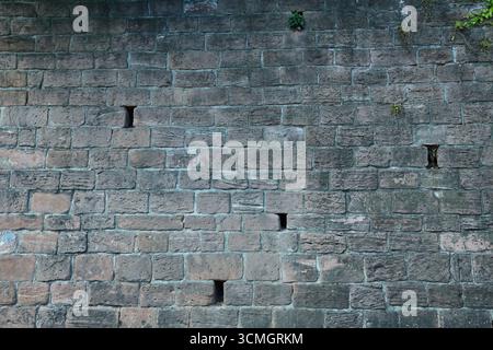 Historic stone wall with drainage holes Stock Photo