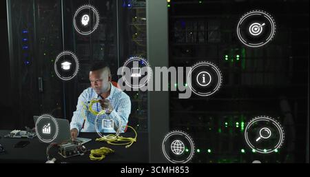 Technician handling yellow Ethernet cables and configuring in data center, with laptop, copy space Stock Photo