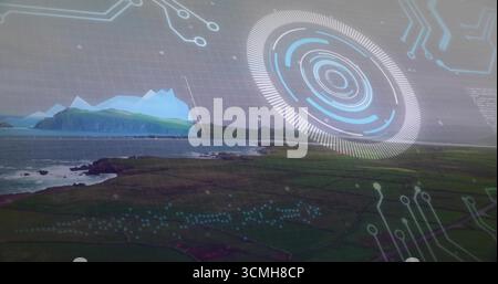 Hovering holographic interface overlaying coastal farmland, with circular HUD graph and circuits Stock Photo