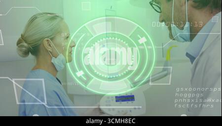 Clinicians reviewing readings on control panel in exam room with holographic overlay Stock Photo