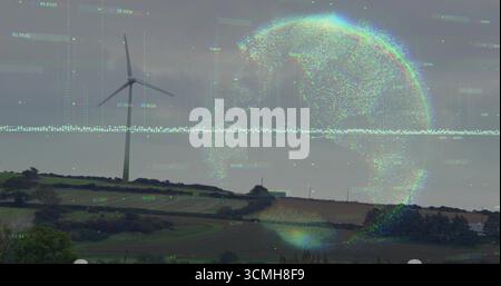Displaying wind turbine spinning in farmland, with digital globe overlay and floating data points Stock Photo