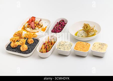 Assorted appetizers with dips, spreads, and vegetables on table Stock Photo