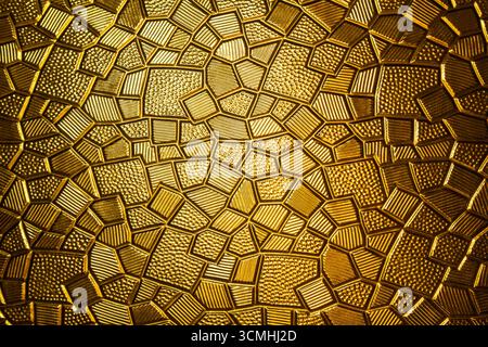 Golden antique metal plate with polygonal texture and geometric pattern, close up Stock Photo