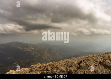 Dark clouds forming over the mountainous landscape of penyagolosa natural park in castellón, spain, create a dramatic and moody atmosphere Stock Photo