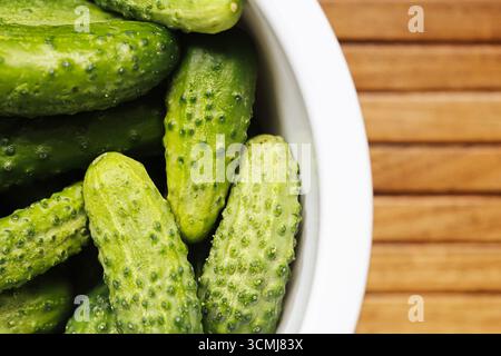 Fresh cucumbers on wooden background. Organic green vegetables for healthy diet. Natural raw food rich in vitamins. Vegetarian ingredients copy space. Stock Photo