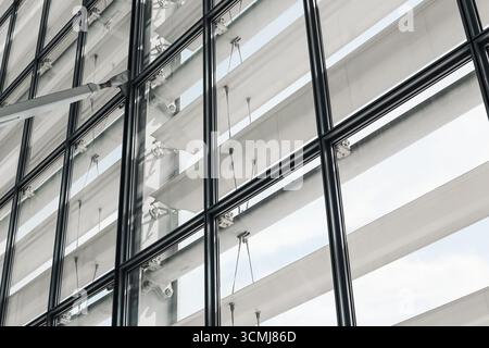 Modern glass building facade. Contemporary architecture with reflection. Urban office exterior with windows. Minimalist geometric design. Stock Photo
