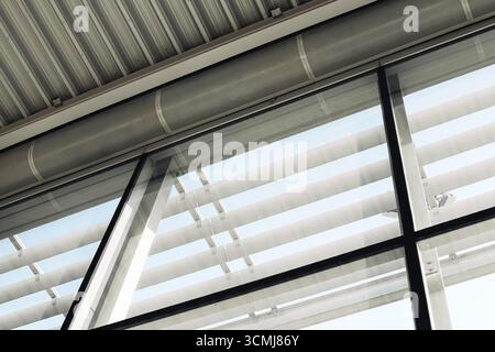 Modern building roof construction. Industrial glass and steel architecture detail. Geometric lines with urban design. Structural interior. Stock Photo