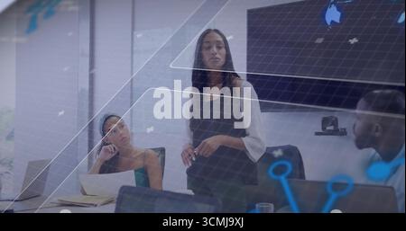 Business leader standing and presenting in office conference room, with laptops and virtual overlay Stock Photo