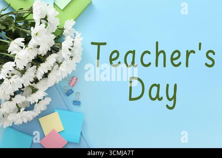 Happy Teacher's Day greeting card with flowers, stationery and text on light blue background Stock Photo