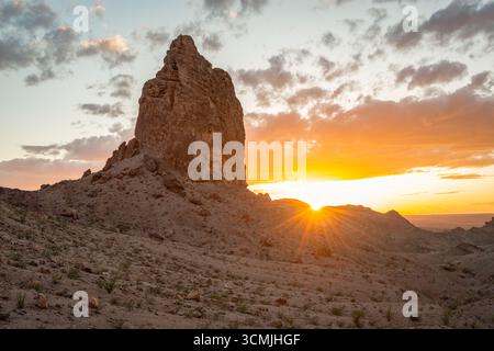 Sun setting behind a rocky peak of the Picacho Mountains at dusk, California, USA Stock Photo