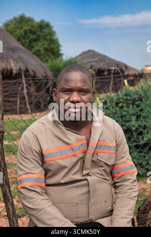 village rural ,portrait of african man, in front of a house with thatched roof , countryside living, Stock Photo