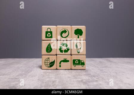 A hand is holding three white cubes with green symbols on them. The cubes are stacked on top of each other, and the symbols on them include a CO2 logo Stock Photo
