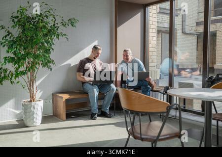 Two knowledgeable professionals collaborating effectively together in a modern workspace setting Stock Photo