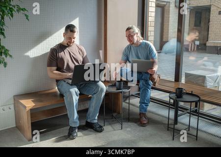 Two It Software engineers working on project and programming in coffee shop. Business people concept. Stock Photo