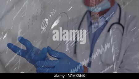 Interacting senior male doctor using holographic charts in lab, with stethoscope and blue gloves Stock Photo