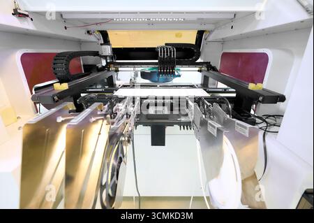 SMT placement machine in action showcasing precise assembly of electronic components on circuit boards Stock Photo