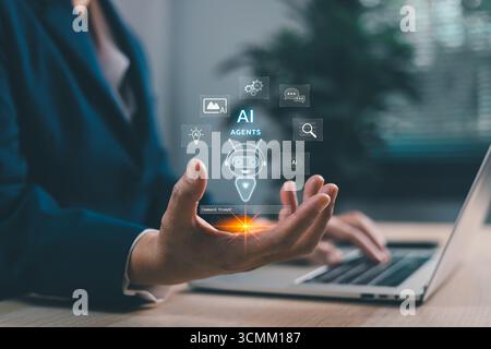 Businessman using laptop with AI agents holographic robot assistant. Artificial intelligence for chatbots, automation, data analytics and digital tran Stock Photo