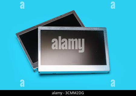 Two old automotive LCD display spares on blue background. Stock Photo