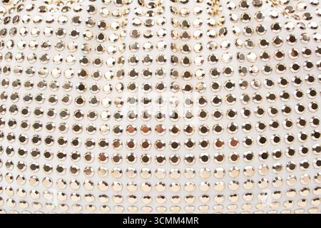 White knitted fabric with many rhinestones pattern. Fashion cloth background texture Stock Photo