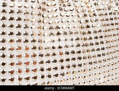 White knitted fabric with many rhinestones pattern. Fashion cloth background texture Stock Photo