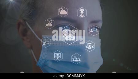 Displaying woman wearing surgical mask viewing floating hexagonal icons in lab, with network theme Stock Photo
