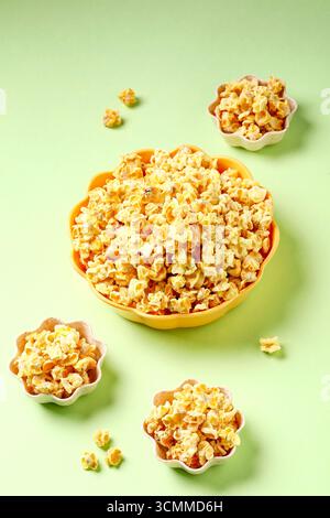 Buttery Popcorn in Colorful Bowls on Green Background - Snack Food Photography Stock Photo