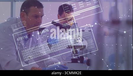 Scientists in lab coats examining samples using microscope at lab bench, with digital data overlays Stock Photo