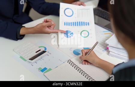 Business Strategy. Team analyzing budget data and financial graphs during a meeting. Stock Photo