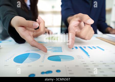 Business Analysis. Team members discussing financial data with charts and graphs. Stock Photo