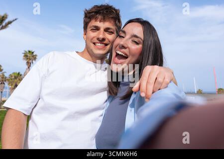 Young couple smiling outdoors posing for selfie together lifestyle moment Stock Photo