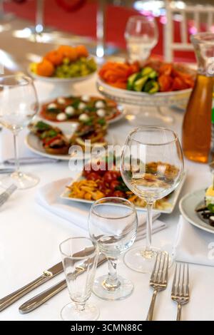 A beautifully arranged plate of assorted bruschetta, canapes, and marinated appetizers on a festive holiday table setting. Stock Photo