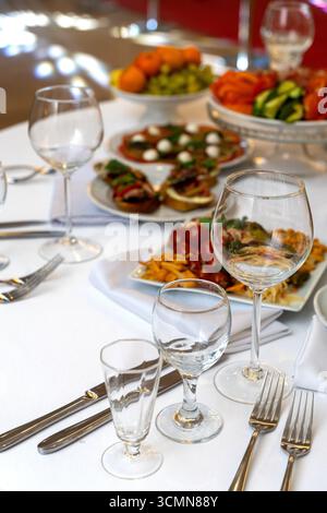 A beautifully arranged plate of assorted bruschetta, canapes, and marinated appetizers on a festive holiday table setting. Stock Photo