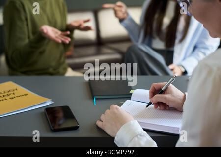 Woman Psychologist Taking Notes during Multiethnic Couple Counseling Stock Photo