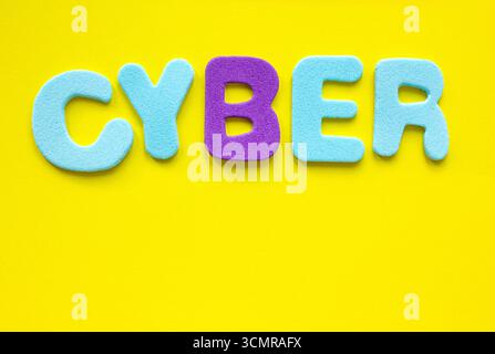 Cyber text with copy space on yellow background, flat lay. Conceptual Cyber symbol. Copy space. Stock Photo