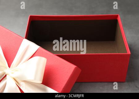 Opened gift box with beautiful lid on grey table, closeup Stock Photo