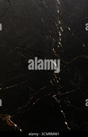 Rich black marble surface with white veins displaying elegant natural patterns and textures suitable for various design applications Stock Photo