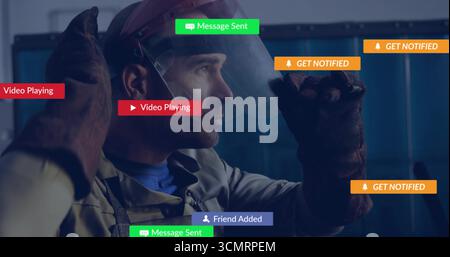 Worker adjusting protective welding helmet visor in factory, with gloves and digital overlays Stock Photo