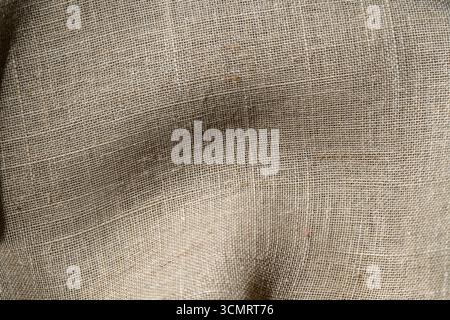 Textured crinkled linen fabric with soft wavy folds,close up. Background and texture of linen fabric Stock Photo