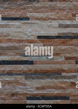 A close-up of a textured stone wall in earthy brown and gray tones, showcasing natural rustic texture ideal for architectural, interior, and design ba Stock Photo