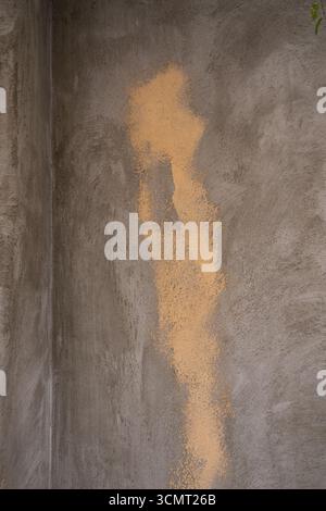 abstract vertical grunge image weathered deteriorating exterior concrete or plaster wall with unique  cream color shape vertical textured  backdrop Stock Photo