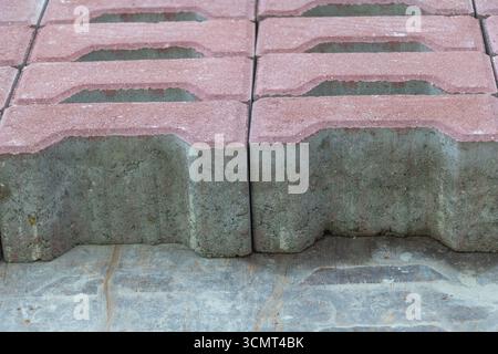 Closeup of red and gray concrete paving blocks arranged in stack, construction materials for sidewalk and outdoor landscaping Stock Photo
