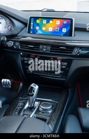 BMW interior center console. central part of car front panel: center console with gear shifter, dashboard, Apple carplay main menu on the top screen. Stock Photo