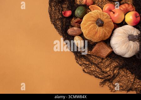 Halloween frame with party decorations of pumpkins, bats, spiders on orange background from above. Happy halloween card in flat lay style. Stock Photo
